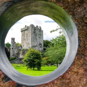 a view of a castle through a hole in a rock wall