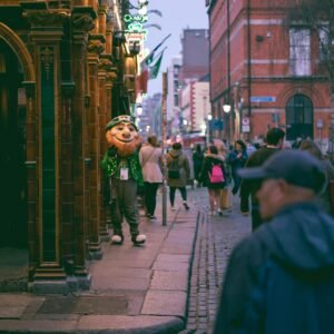 a group of people walking down a street next to tall buildings